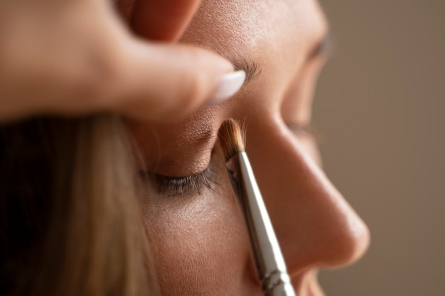 Close-up of a woman applying eyeshadow with a makeup brush