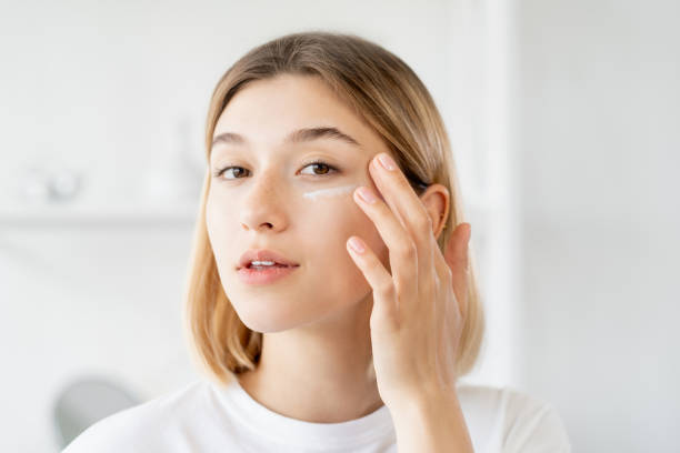 Young woman applying skincare product